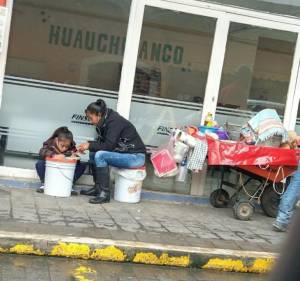 En las calles de Huauchinango una niña toma clases junto al puesto de su madre