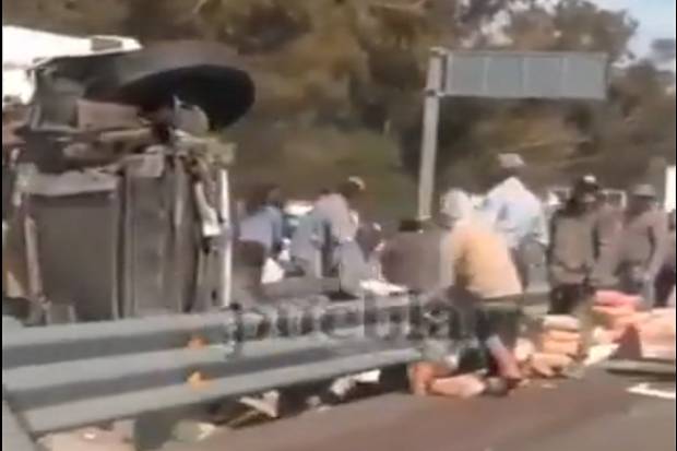 VIDEO: Vuelca tráiler con bultos de cemento y la rapiña no se hizo esperar