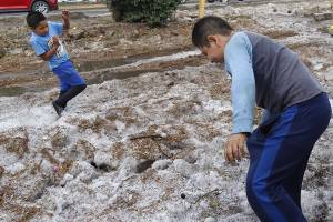 Niños aprovechan para jugar con granizo mientras limpian calles de la colonia Satélite