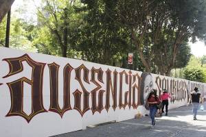 Protesta por desaparecidos y cuidado del bosque, en muro provisional del zócalo de Puebla