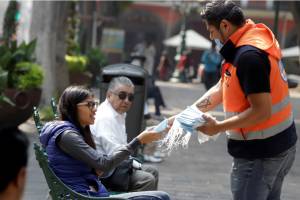 Protección Civil reparte cubrebocas en el zócalo de Puebla por contingencia ambiental