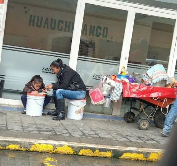 En las calles de Huauchinango una niña toma clases junto al puesto de su  madre