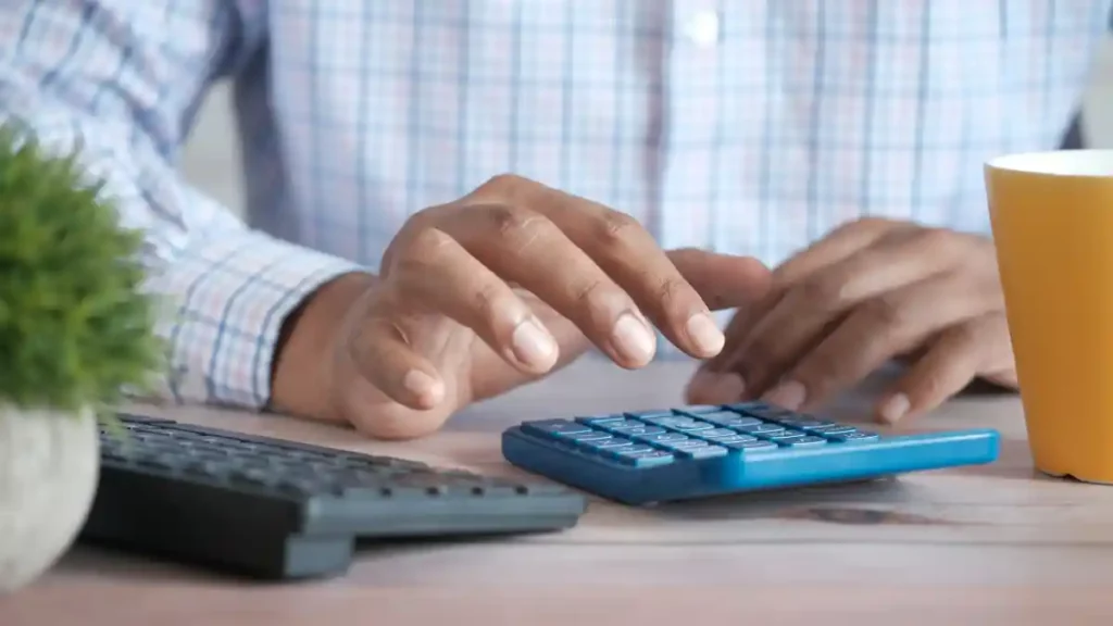 Hombre utilizando una calculadora para hacer el cálculo de finiquito.