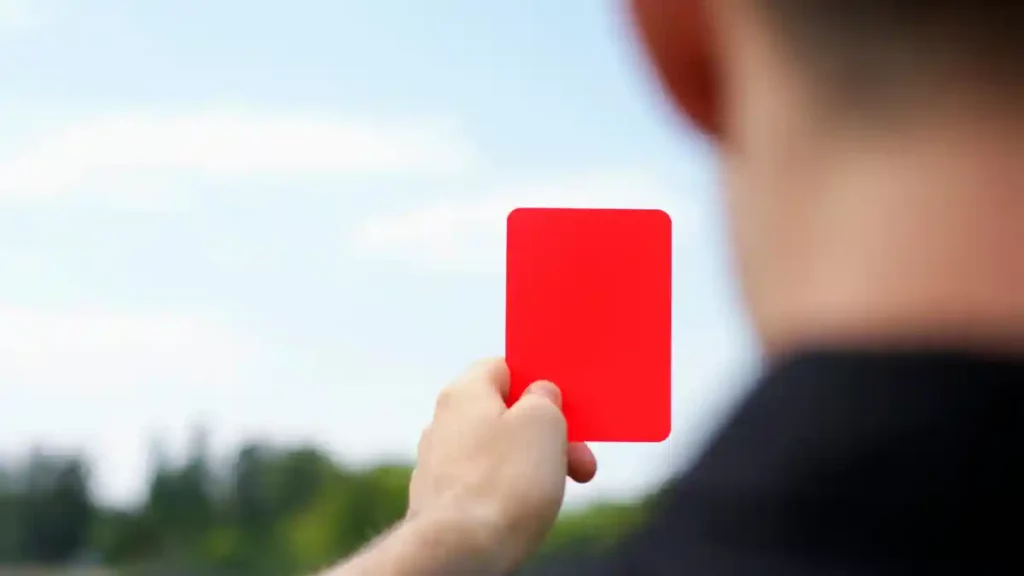 Un árbitro mostrando una tarjeta roja en un partido de fútbol.